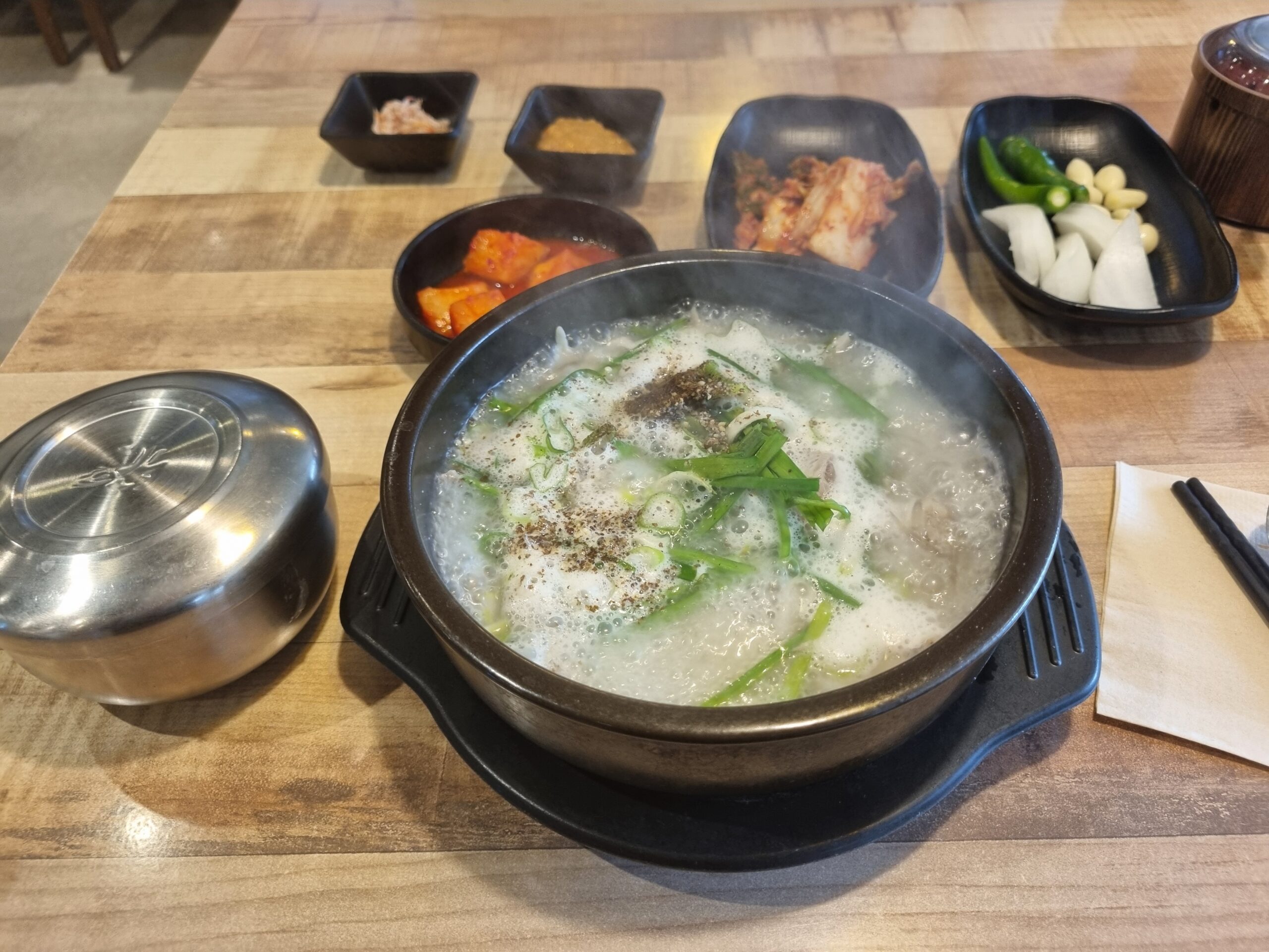 A full gukbap table setting with soup, rice and several side dishes