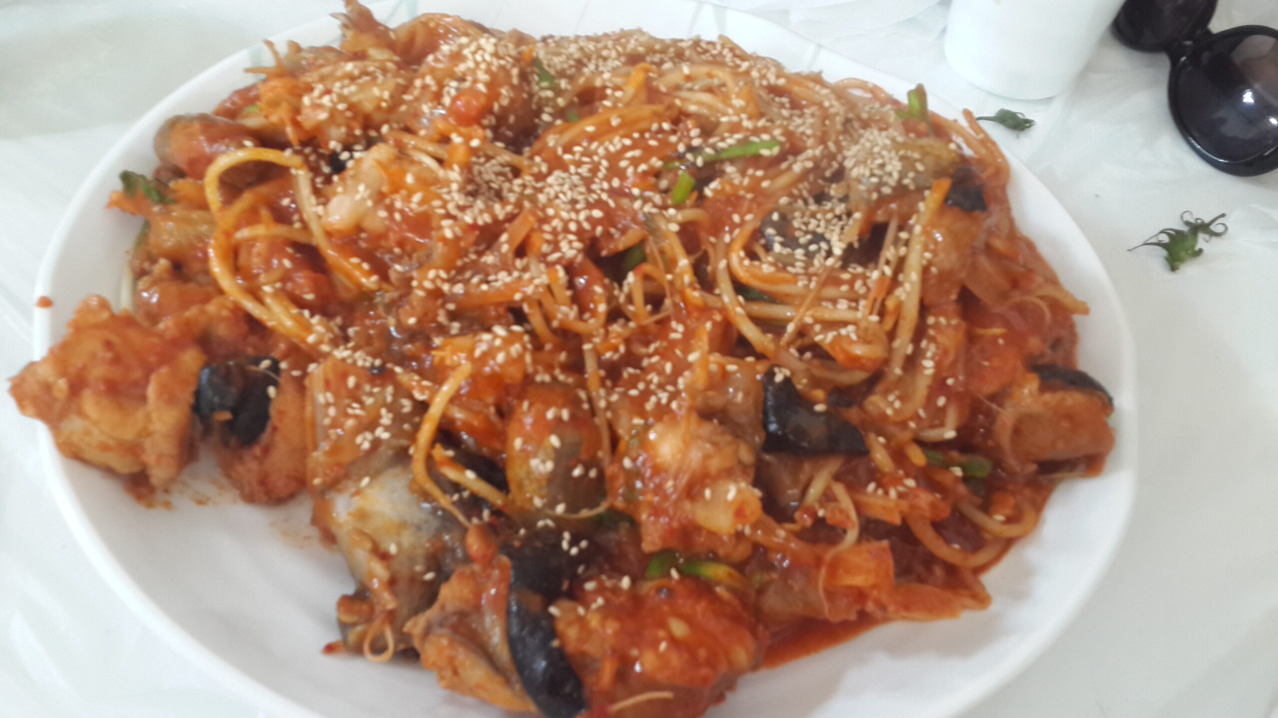 A large platter of monkfish in thick red chilli sauce over soybean sprouts