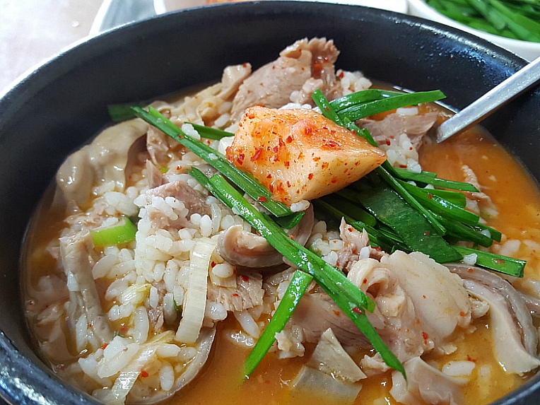 A bowl of pork broth with rice