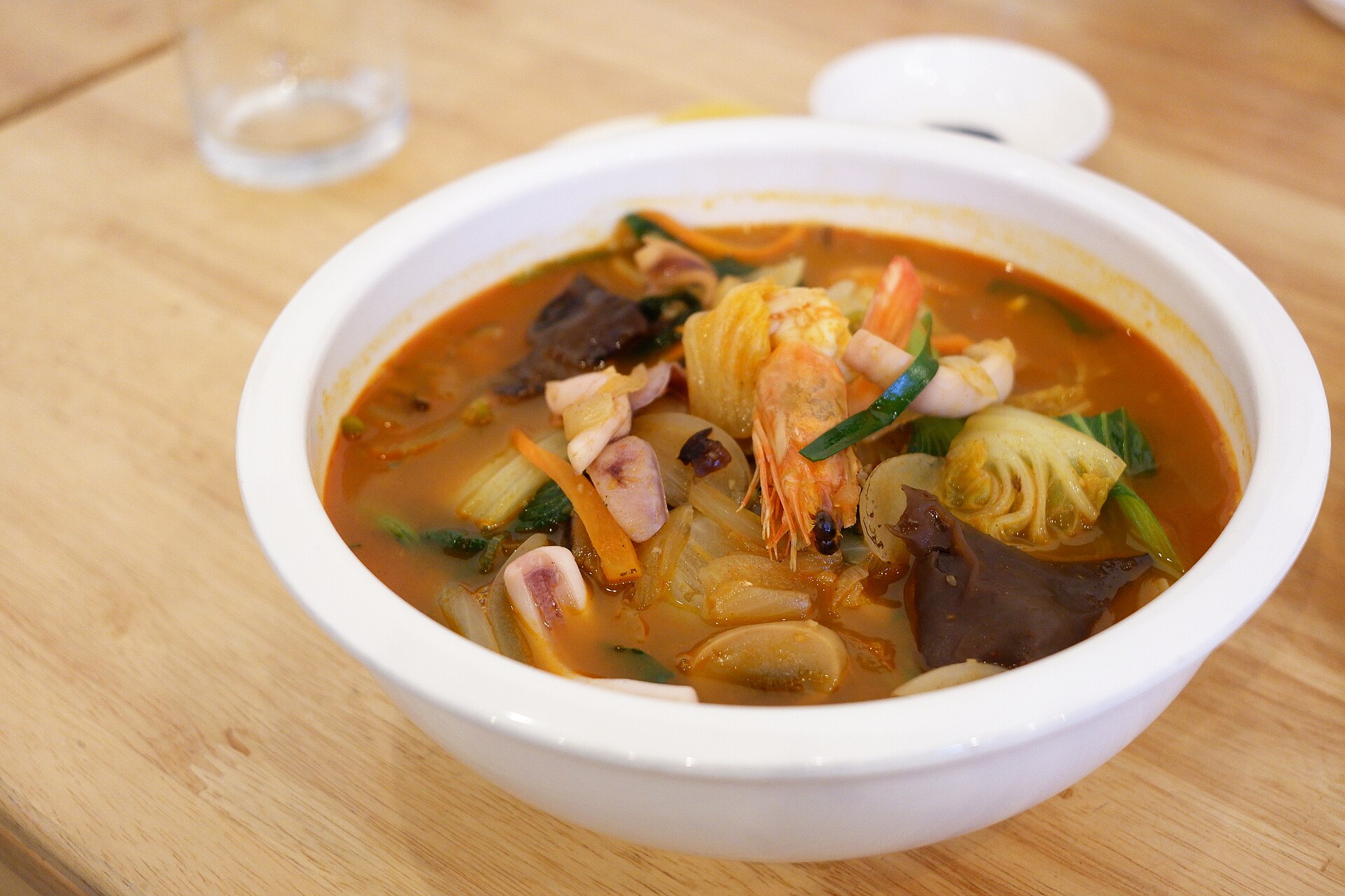 A deep red spicy seafood noodle soup
