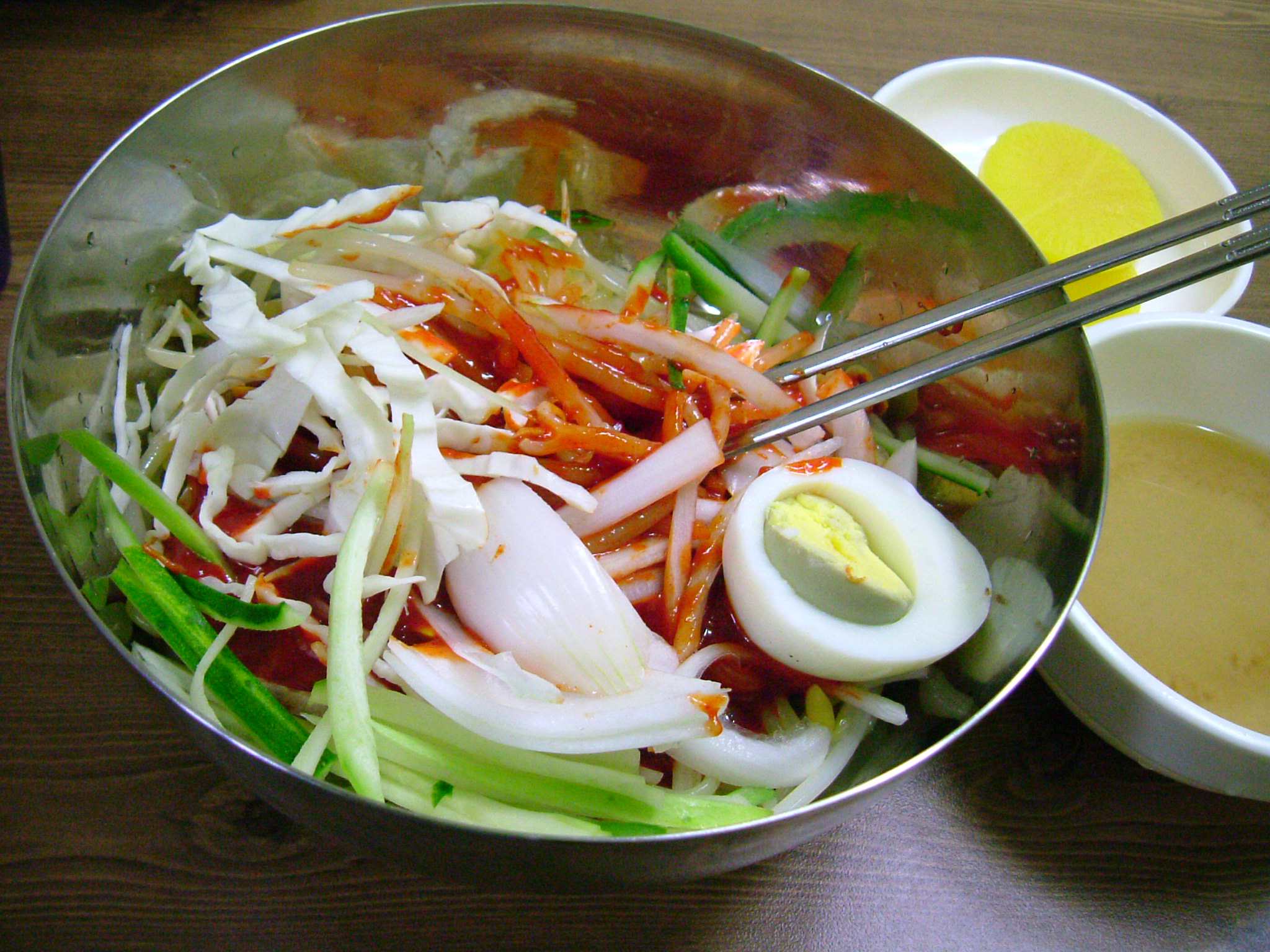 Very chewy noodles with raw vegetables in red sauce