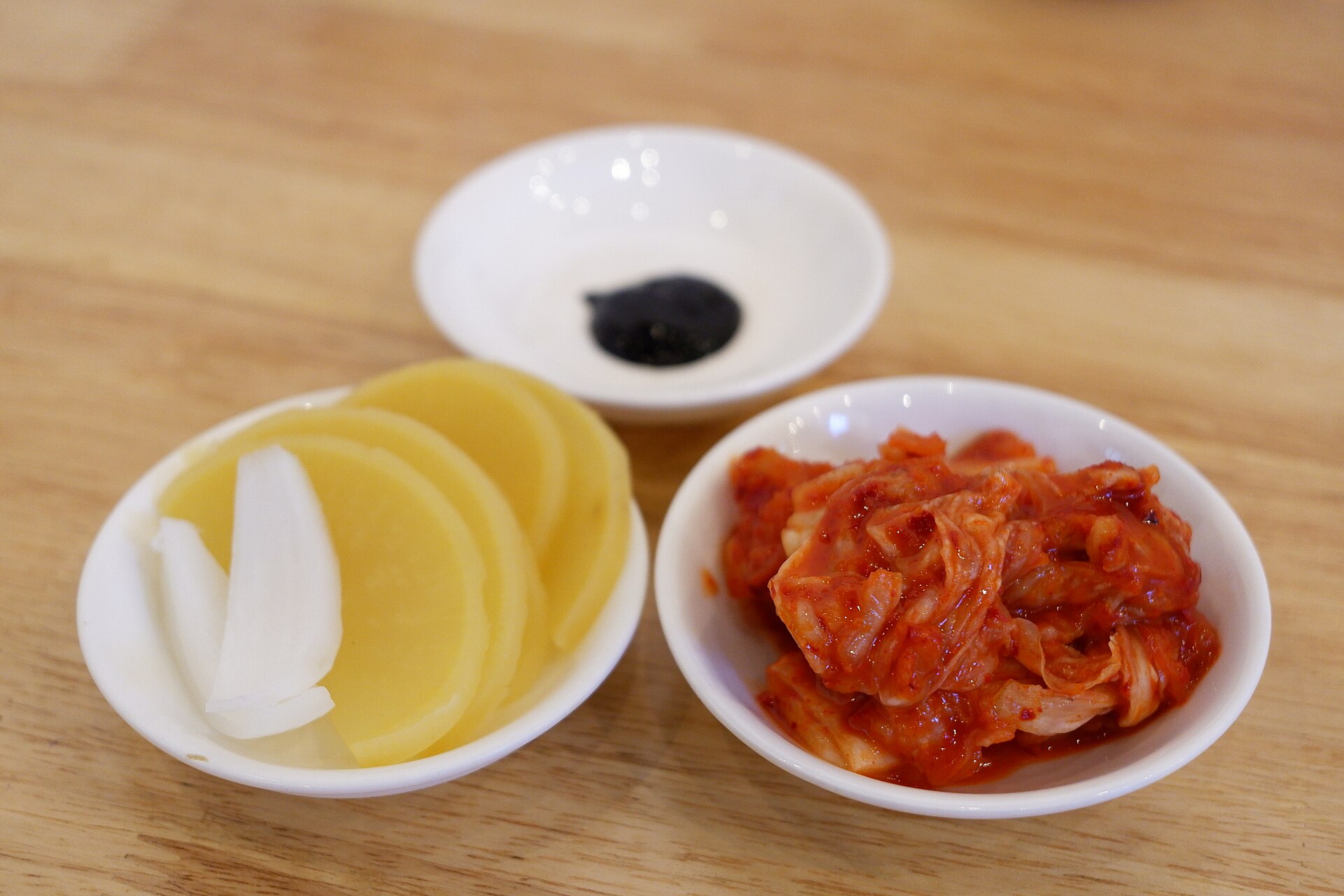 Pickled radish, raw onion and black bean paste on a table