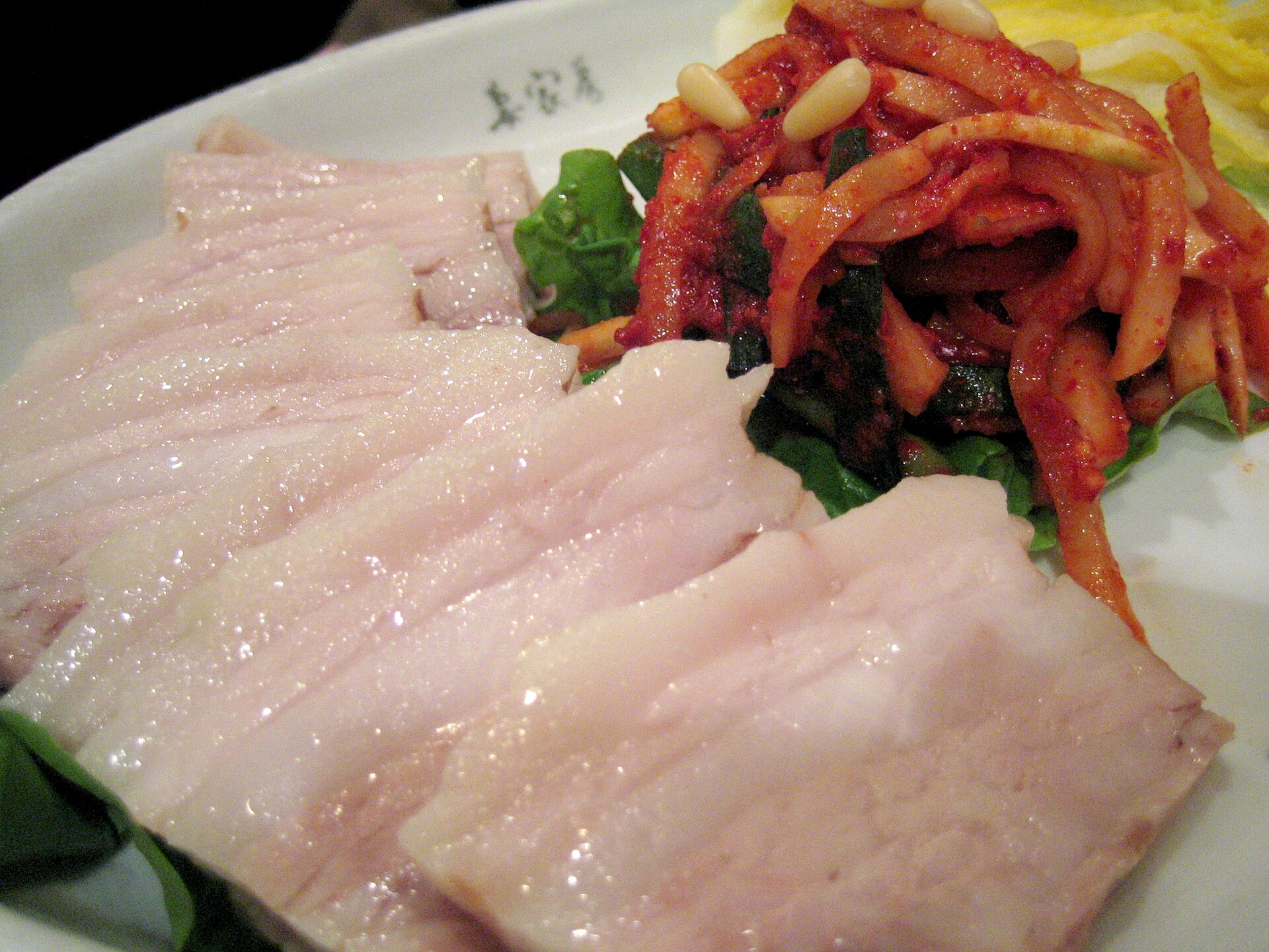 Sliced boiled pork belly served with cabbage and kimchi