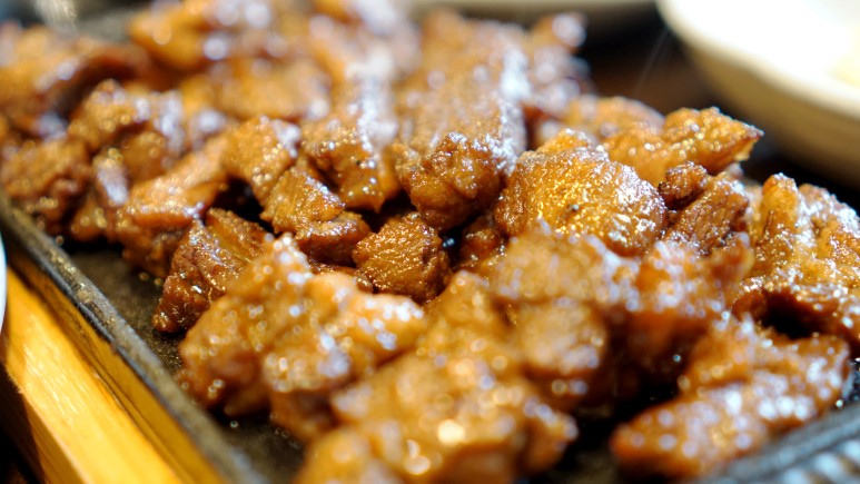 Marinated pork ribs in a dark soy-based sauce before grilling